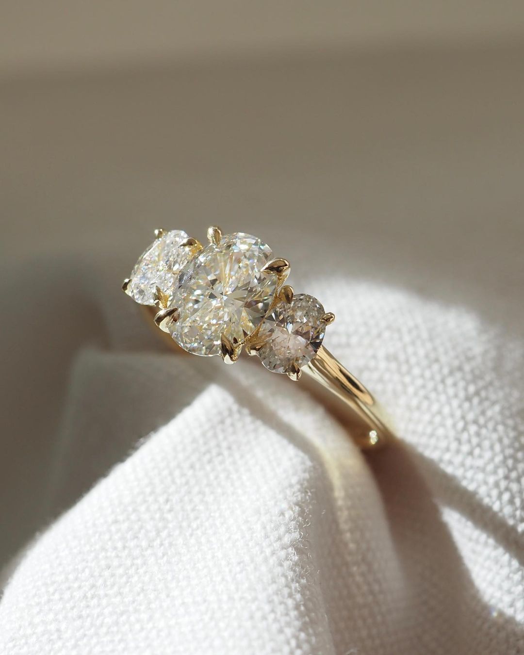 2.5ct Trio Oval Cut Lab Grown Diamond Ring The hand displays a soft, natural manicure, highlighting the diamond's brilliance and the ring's refined craftsmanship. Ideal for those seeking timeless, high-end accessories for special occasions. Luxurious diamond Ring, Wedding Ring, Anniversary and Promise Ring For Her