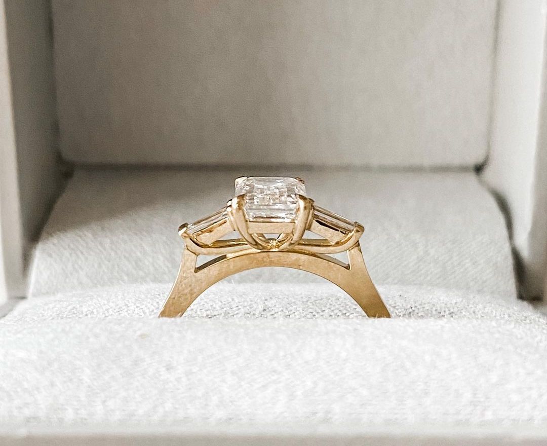 2.5ct Emerald Center Stone With Two Side Baguette Stone Lab Grown Diamond Ring By Avxy Jewels Stunning diamond solitaire ring on a gold band, ideal for engagements, weddings, or fine jewelry collections.