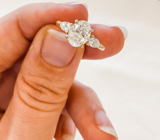 3ct Brilliant Oval Stone With Two Pear Shoulder Stones Lab grown Diamond Ring Minimalist  diamond ring on a gold band, symbolizing timeless elegance, showcased on a naturally manicured hand. diamond ring, gold engagement ring, luxury bridal jewelry  and anniversary diamond ring YouTube Amazon Facebook Weather Google Gmail Wordless WhatsApp Web Translate News blog post ring ceremony Article Life Money 2025 design Ring Ceremony Diamond Shape Diamond Ring Surat Diamond India Market Diamond Ring for Her Diamond