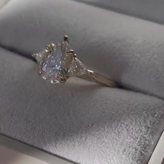 4ct Pear Cut With Central Stone With Two Side Trillian Stone Lab Grown Diamond Ring Close-up of an exquisite gold-band ring featuring a diamond, ideal for engagement celebrations or luxury jewelry enthusiasts. The soft manicure enhances the refined and elegant appeal. YouTube Amazon Facebook Weather Google Gmail Wordless WhatsApp Web Translate News blog post ring ceremony Article Life Money 2025 design Ring Ceremony Diamond Shape Diamond Ring Surat Diamond India Market Diamond Ring for Her Diamond Ring  